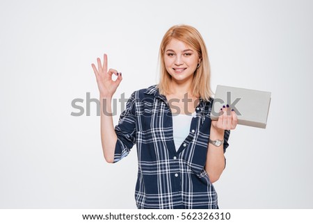Picture of positive young woman holding book isolated on a white background make okay gesture.