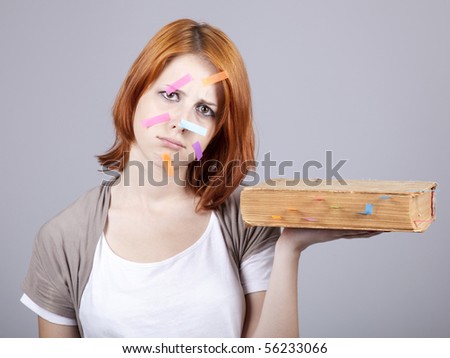 Red-haired businesswoman with book and notes on face.