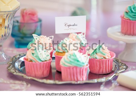 colorful cupcakes with butterflies on a holiday table