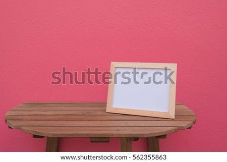 photo Frame on a wooden on pink background .