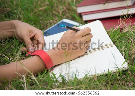 right hand writing on a book