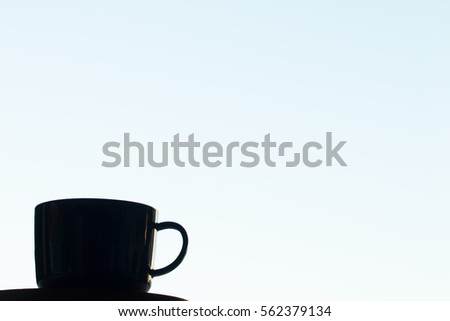 Silhouette of a teacup against blue sky background horizontal