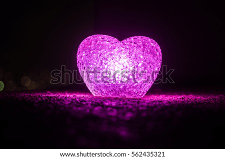 Valentine's Day composition with sweet burning multicolored heart on dark background, selective focus, or love greeting card of heart red green pink yellow