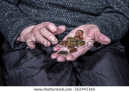 An old woman counts her few coins