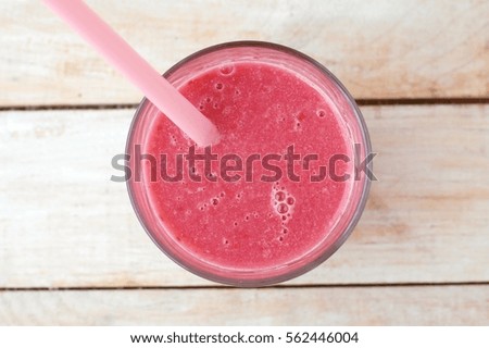 Healthy fresh smoothie drink from raspberries and coconut in glass with straw, overhead horizontal view