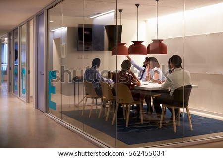 Corporate business team using AV display in meeting cubicle Royalty-Free Stock Photo #562455034