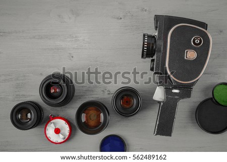 Old movie camera with interchangeable lenses and color filters on the old table
