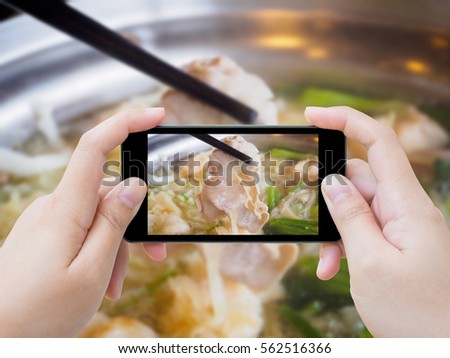 woman taking photo of sukiyaki shabu shabu with mobile smartphone