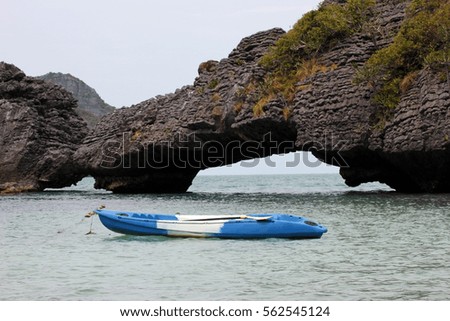 Kayaking in the sea with natural stone bridge in the archipelago island Thailand.