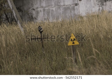 you can see the sign in the grass and radiation cross with a gas mask, an exclusion zone is dangerous