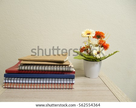 The book and flower vase on table