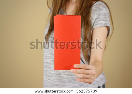Girl showing blank red flyer brochure booklet. Leaflet presentation. Pamphlet hold hands. Woman show clear offset paper. Sheet template. Booklet design sheet display read first person