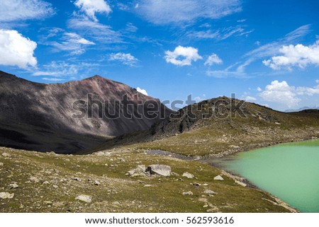 Amazing picture of green mountain landscape with blue sky and white clouds. Great nature,sunlight at the middle of summer day. Lake and color hill.