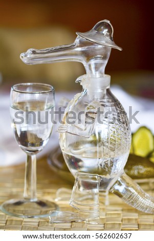 Still life with a decanter and a glass of vodka with pickles
