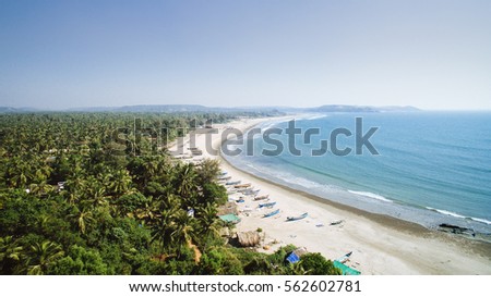Tropical beach with ocean and palm taken from drone. Goa India - aerial view photo. Royalty-Free Stock Photo #562602781