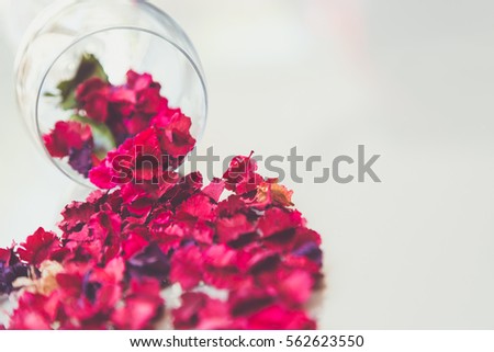 The wine glass with dried rose petals