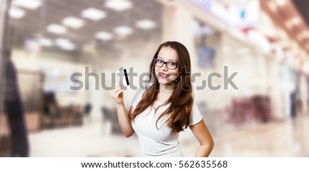 cute, attractive, girl with a credit card in hand on office background, shopping