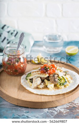 Healthy tostado with scrambled eggs, grilled vegetables and salsa 