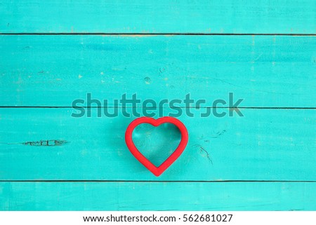 Bright red heart on antique rustic teal blue wood background; Valentine's Day and love concept with copy space