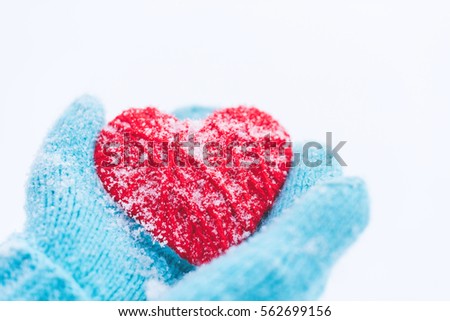 Blue knitted gloves with woolen heart. St. Valentine's Day greeting card 
