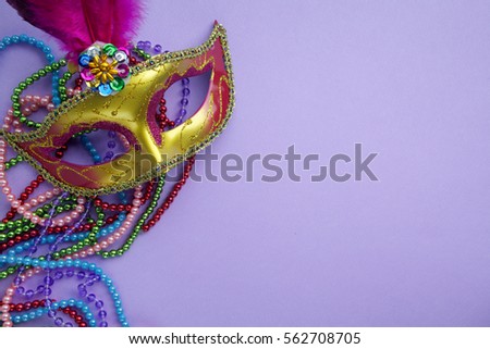 Festive, colorful group of mardi gras or carnivale mask on purple background.