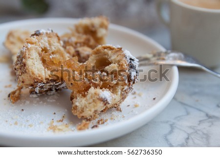 Turkish dessert: baked cookie with apple jam on the white plate with espresso cup in the background. Marble table surface. Crushed cookie with apple jam