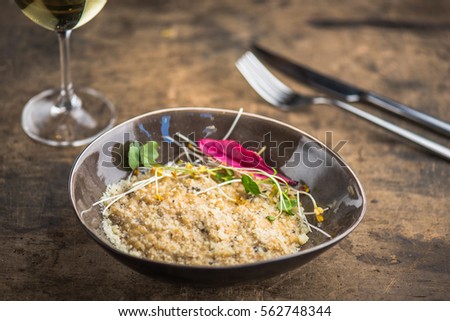 Snack in a plate and a glass of wine. Food close-up on a wooden table.