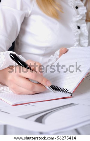 hand of a young business woman working with documents. Workplace of business people.