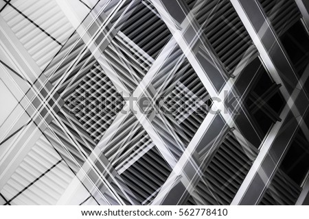 Overlay of grid structures. Grunge reworked photo of louvered windows. Abstract black and white image on the subject of industrial architecture and interior. Royalty-Free Stock Photo #562778410