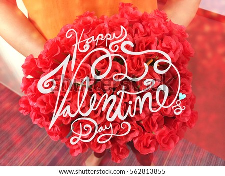 Happy Valentine's Day word lettering on red roses bouquet in woman hand with bokehn effect