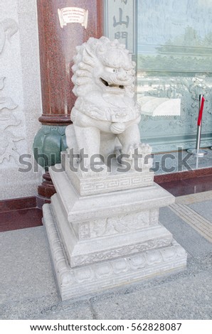 Chinese guardian lion. People are visiting. Located in Chinese Temple.