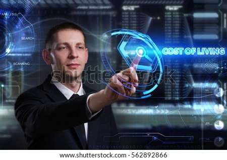 Business, Technology, Internet and network concept. Young businessman working on a virtual blackboard of the future, he sees the inscription: cost of living 