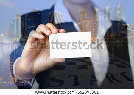 Double exposure of business woman hand showing a blank empty name card on city buildings background and start wording, Business and construction concept.