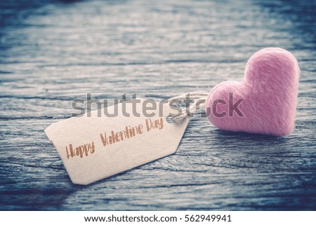 pink heart shape with happy valentine day text over paper tag on wooden table background ,vintage color tone,Image for Happy valentine day concept.