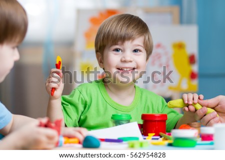 Children creativity. Kids sculpting from clay. Cute little boys mould from plasticine on table in kindergarten Royalty-Free Stock Photo #562954828