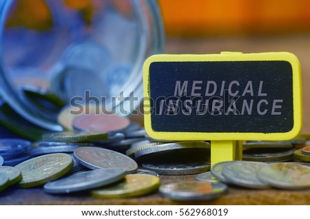Finance conceptual image with MEDICAL INSURANCE words, hundred dollar bills, coins in a jar, a magnifying glass and calculator on wooden background. tone image.