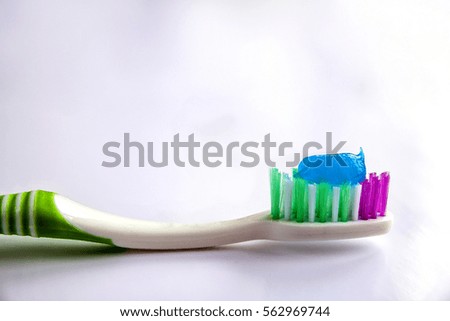 Toothpaste on a toothbrush close-up on a white light background