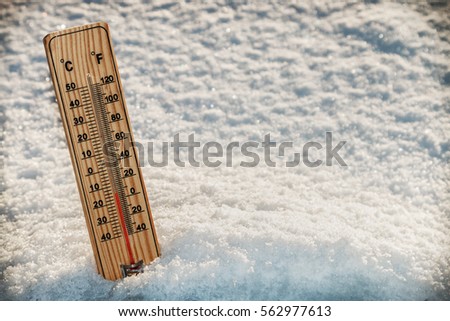Wooden Thermometer in the snow with freezing temperatures. vignetting as an artistic effect