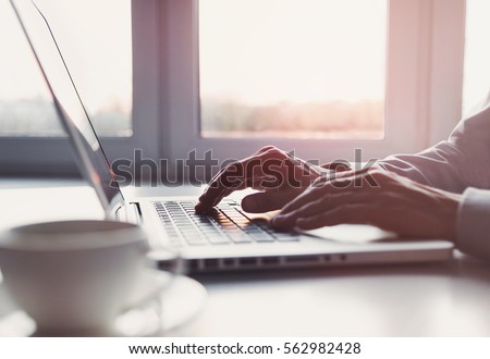 Business man using laptop computer at home. Male hand typing on laptop keyboard in office. Businessman, student, work from home, distance education, online learning, studying concept Royalty-Free Stock Photo #562982428