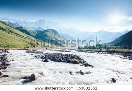 Rapid river at the foot of the glacier Shkhara. Picturesque and gorgeous scene. Location place Svaneti, Mestia, Georgia, Europe. High Caucasus ridge. Vintage effect. Instagram filtered. Beauty world.