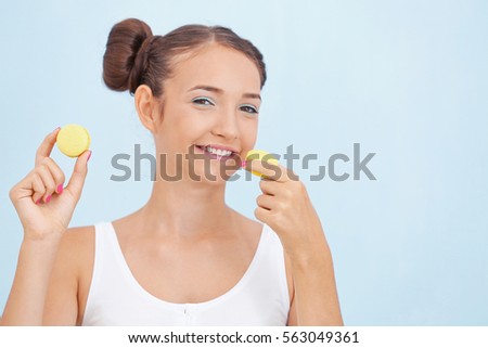 Cute girl with macaroons on light background