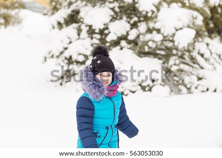 Portrait of a Girl in the winter forest. A child playing in the snow