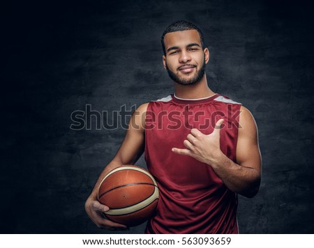 Portrait of a bearded black man holds a basket ball.