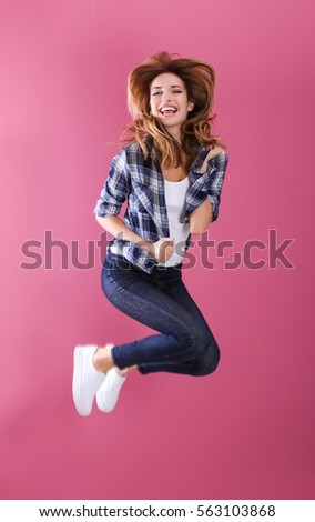 Beautiful young woman having fun on color background