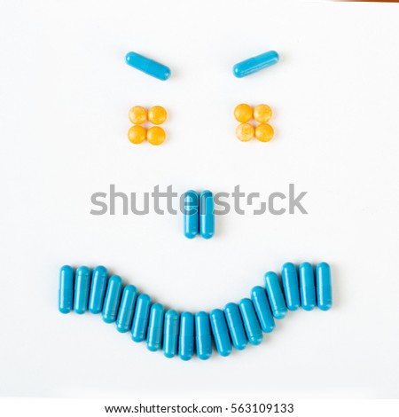 Angry smile made from many pills and capsules. wellness concept.