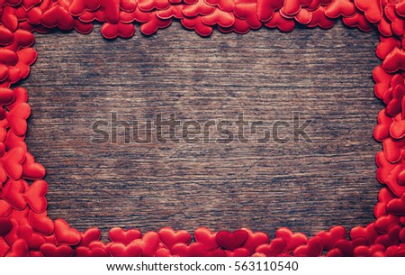 Frame of red heart on wooden background with copyspace.