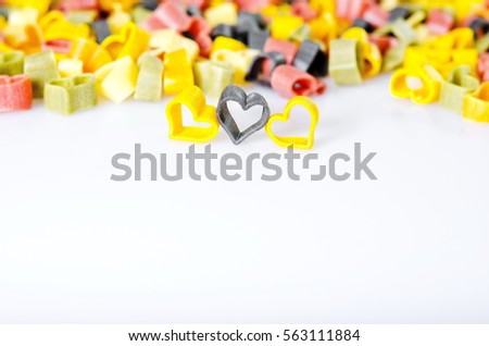Heart-shaped colored Italian pasta on a white background. Heart of pasta. Italian pasta hearts shaped. spaghetti on a white background.  colored hearts.  a lot of colored hearts. male and female, 

