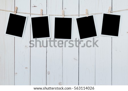 five photo frame blank hanging on wooden board background.