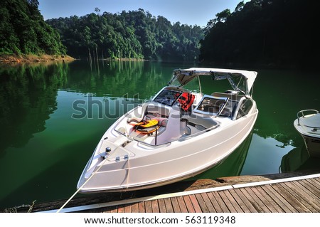 Fishing boat (tourist boat ) at tropical rain forest at Kenyir Lake in Terengganu, Malaysia, It is the largest man-made lake in South East Asia. Royalty-Free Stock Photo #563119348