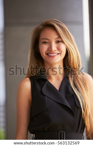 Young Asian businesswoman looking to camera, vertical